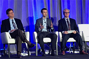 Rx Savings Solutions founder and CEO, Michael Rea, sits on stage with a panel during an industry conference