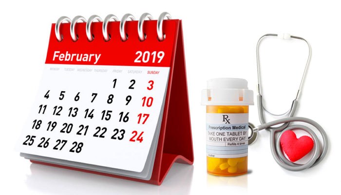 A calendar displaying February 2019 next to a prescription drug bottle and stethoscope