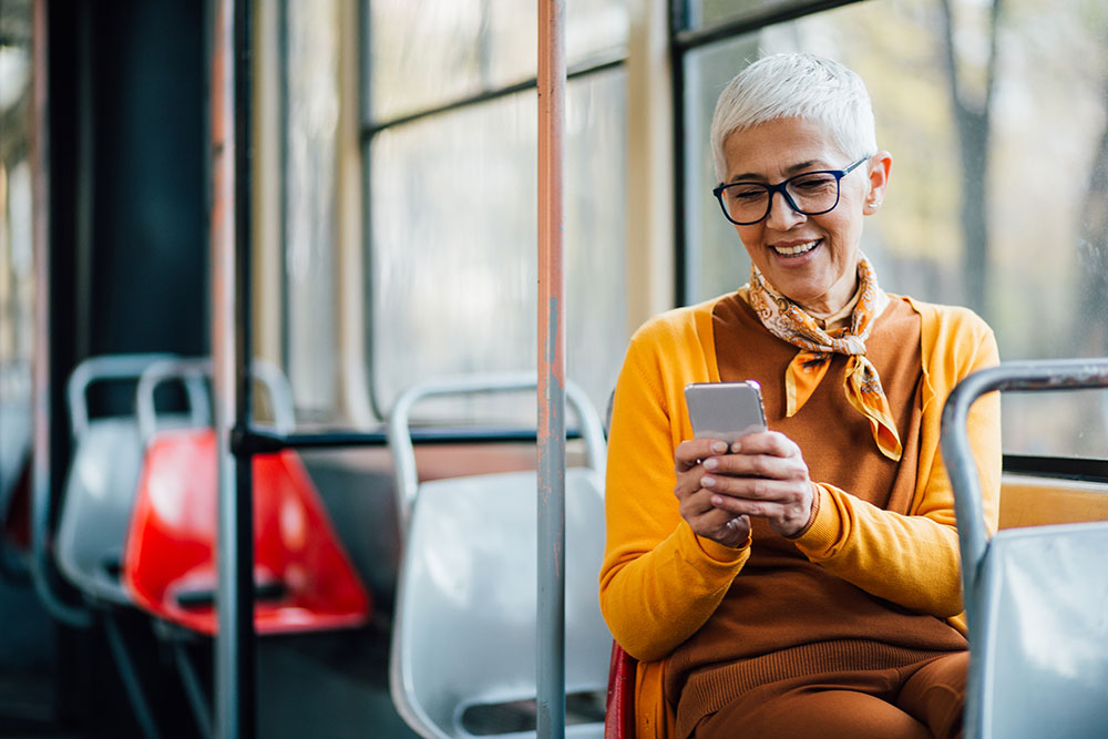 A woman using her phone while riding on a bus