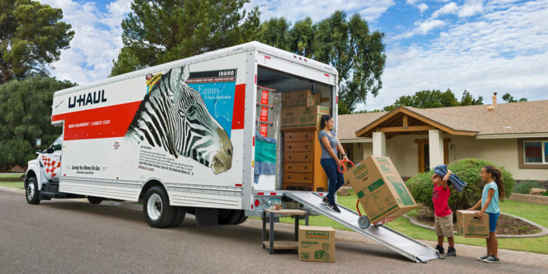 A woman taking boxes off a U-Haul truck