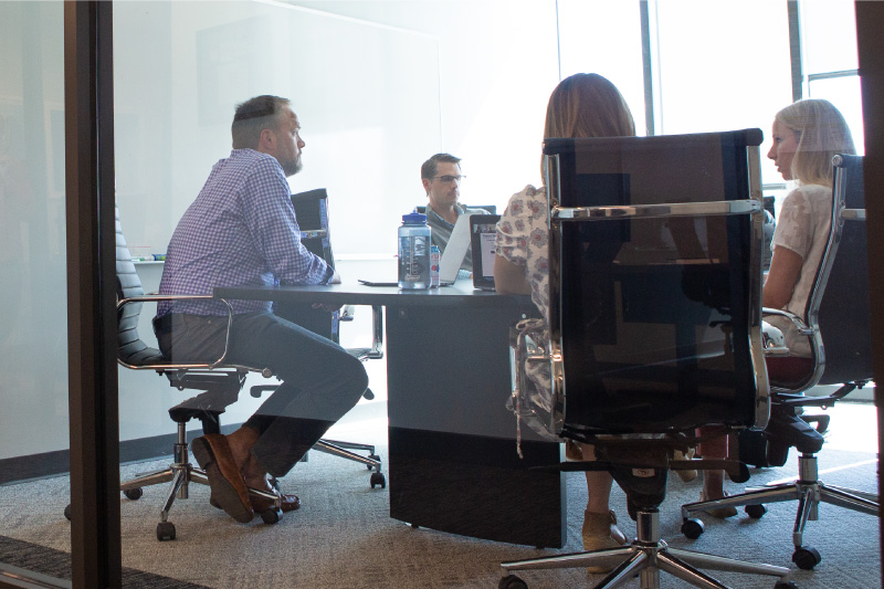 Members of the Rx Savings Solutions Pharmacy and Therapeutics (P&T) Committee in a conference room sitting around a table