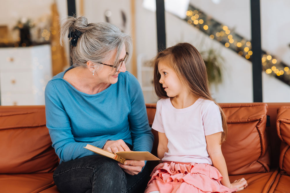 Nice elderly woman reading a story to a young girl