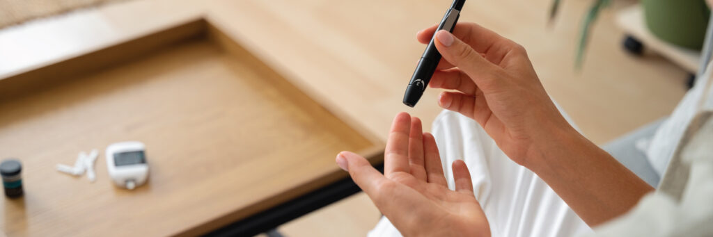 A patient injects her fingertip with a pre-filled pen injector for weekly GLP-1 type 2 diabetes and weight-loss treatments
